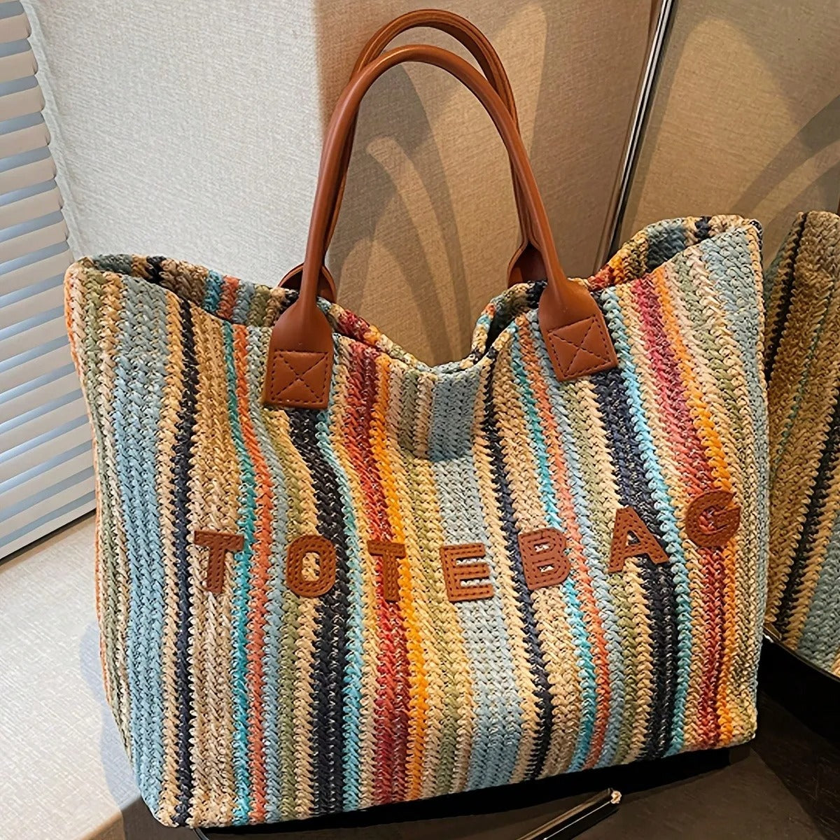 This stylish, colorful striped straw tote bag features a bohemian-style handwoven letter pattern and contrasting colors. A versatile and simple shoulder bag, perfect for summer beach vacations, everyday outings, or shopping.